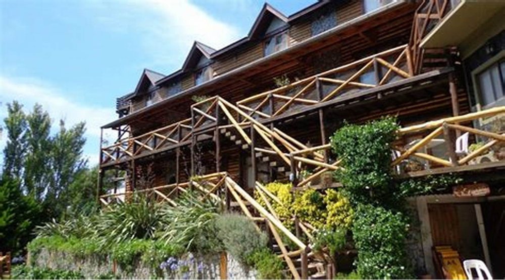 El edificio de troncos con sus balcones, visto desde el camino.