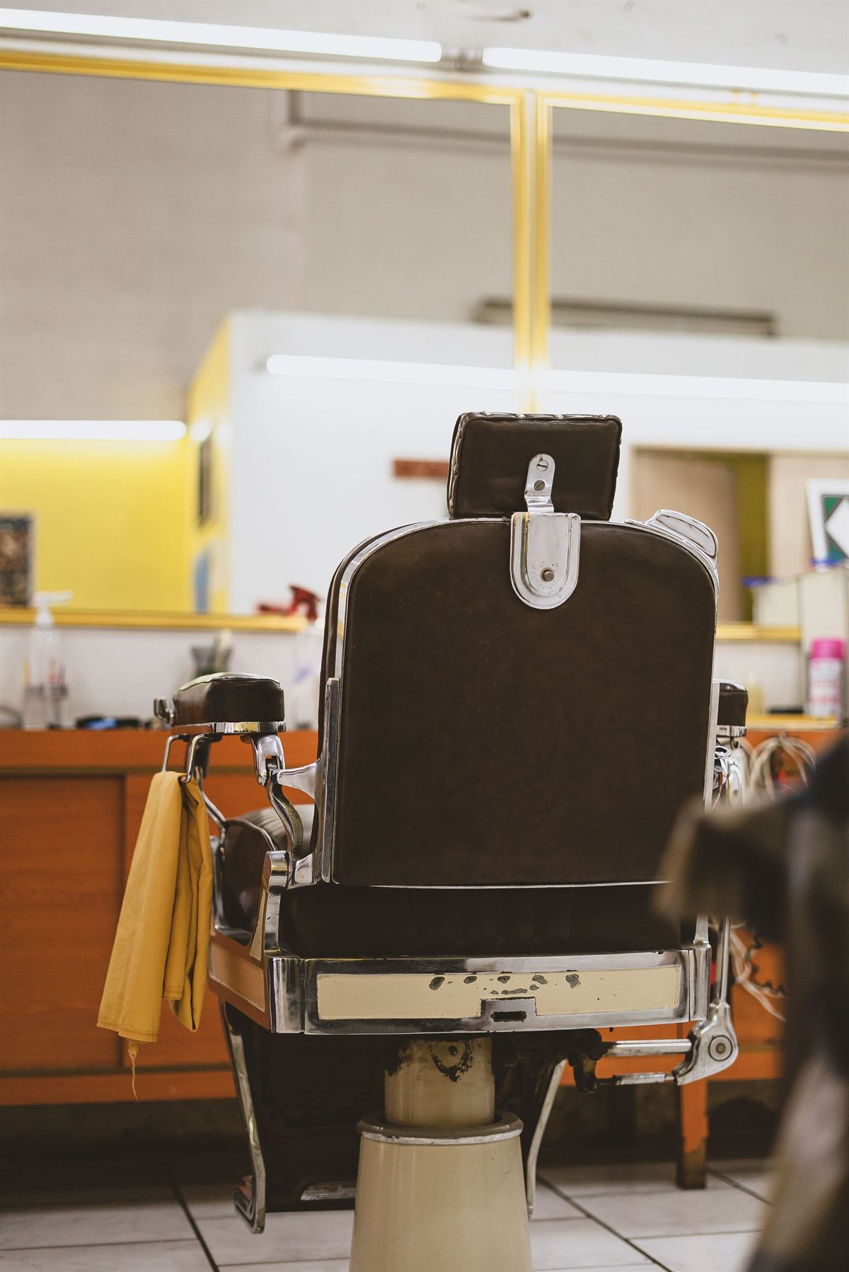 Sillón de barbero vacío, con el respaldo de cuero y el pedal cromado