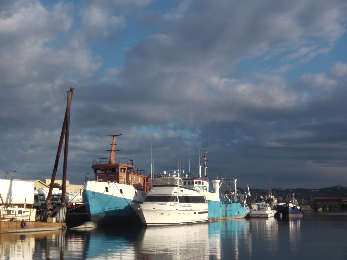 Lanchas y barcos amarrados en el puerto, con el cielo nublado detrás