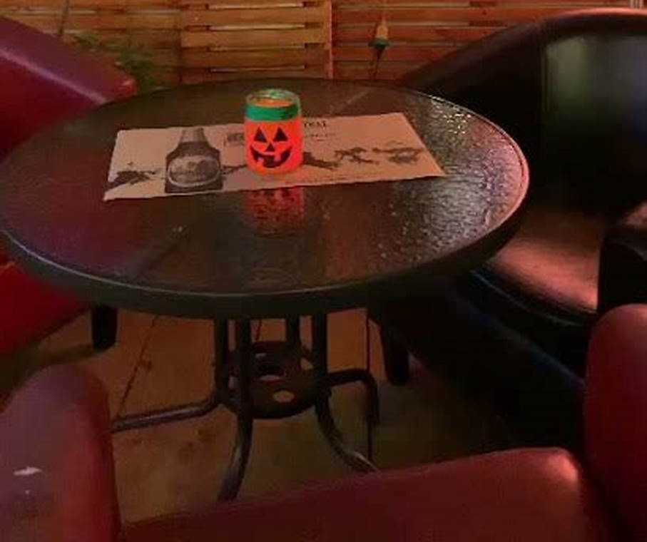 Una mesa redonda con sillones de cuero en un rincón del local.
