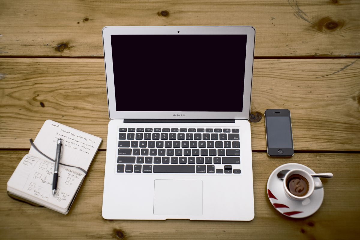 Cuaderno y computador sobre el escritorio
