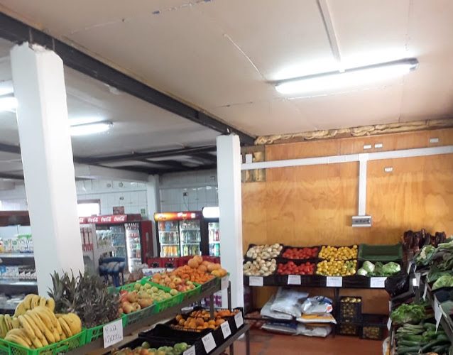 Pasillo interior del supermercado, con la sección de frutas y verduras en primer plano.