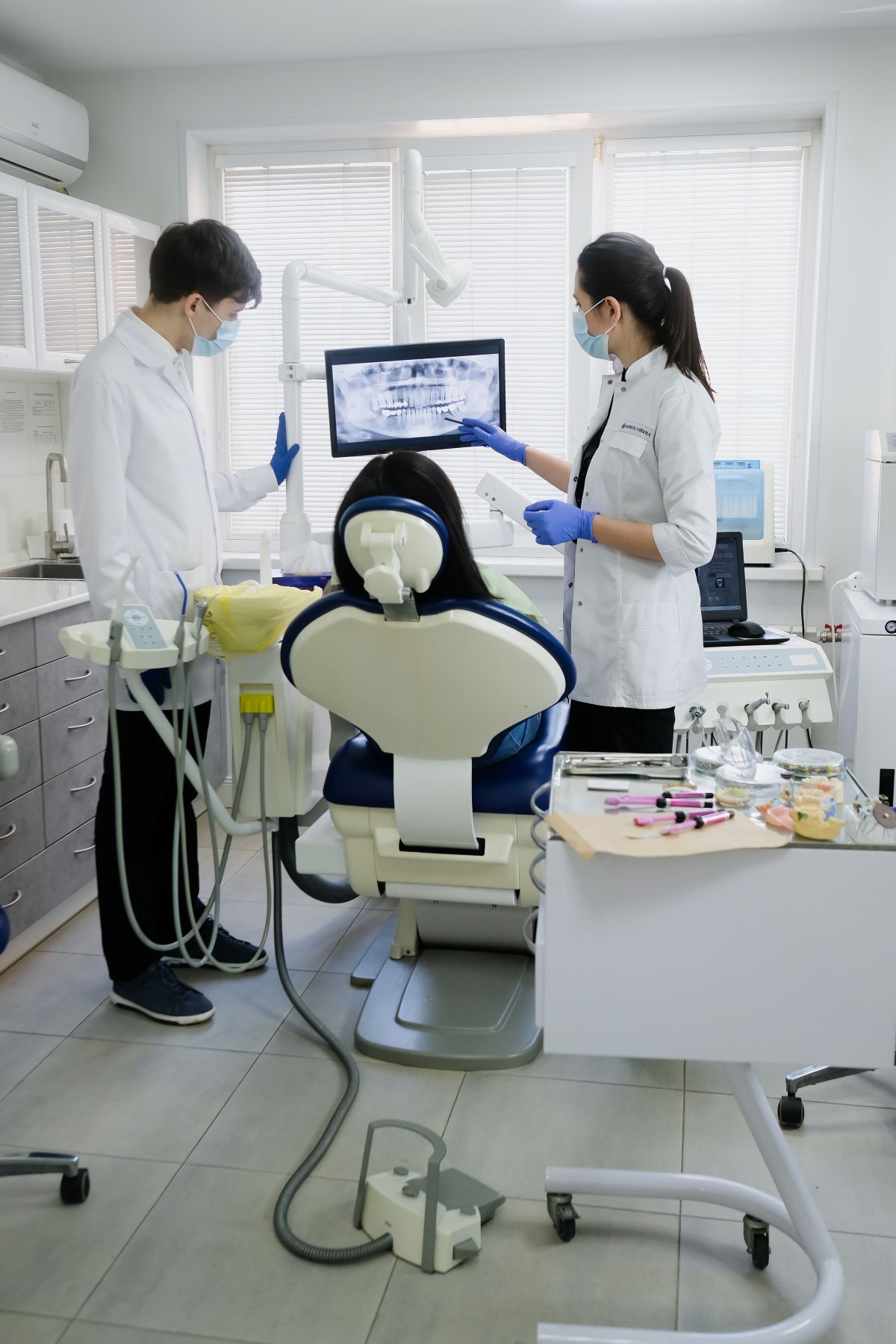 Dos profesionales revisando la radiografía panorámica en la pantalla del box