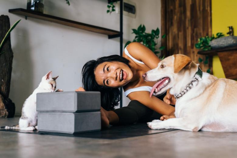 Una mujer en el suelo de su casa, entre su perro y su gato.