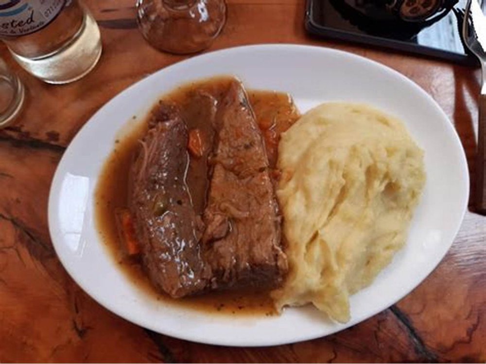 Un trozo de carne con puré, en el plato.