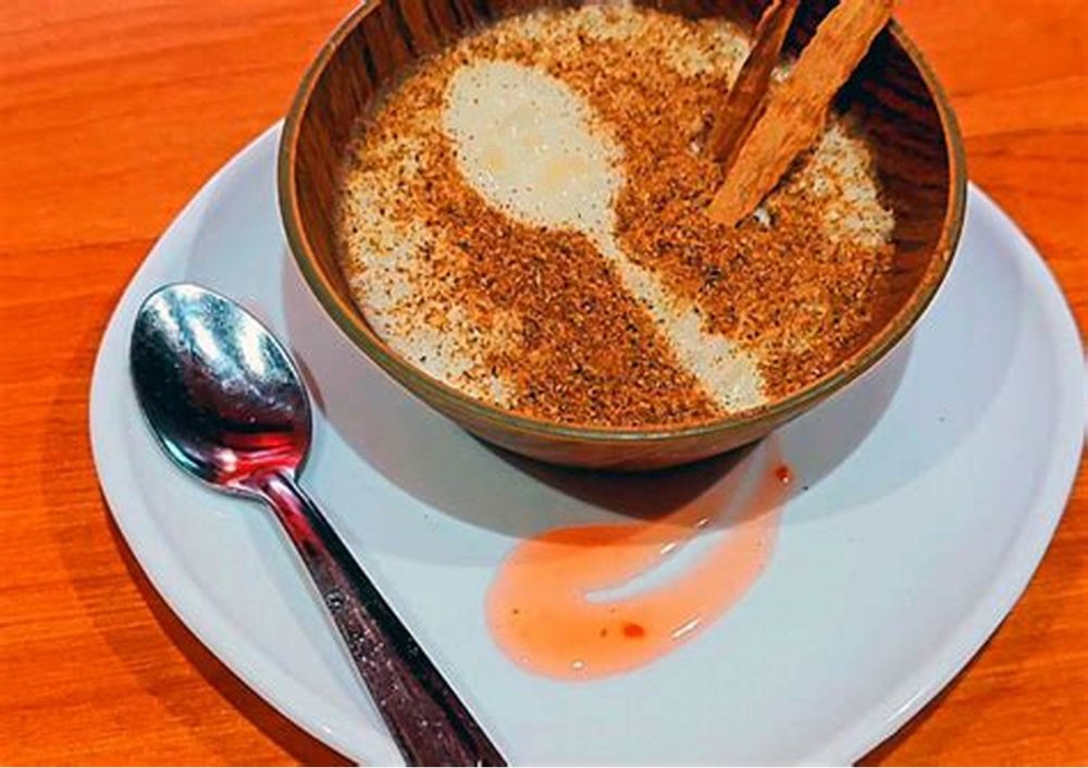 Un postre en bol de madera, con canela encima.