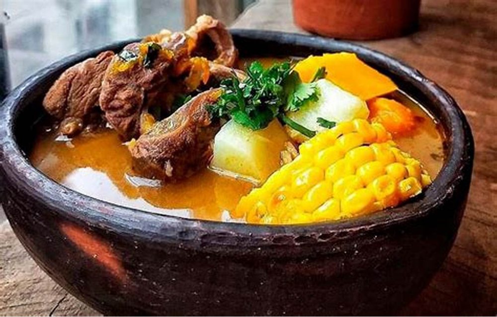 Una cazuela servida en pilón de greda, con choclo y zapallo.