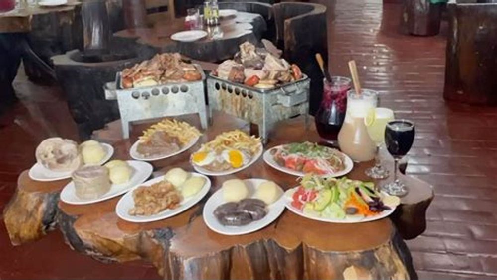 Mesas de troncos con los platos servidos.