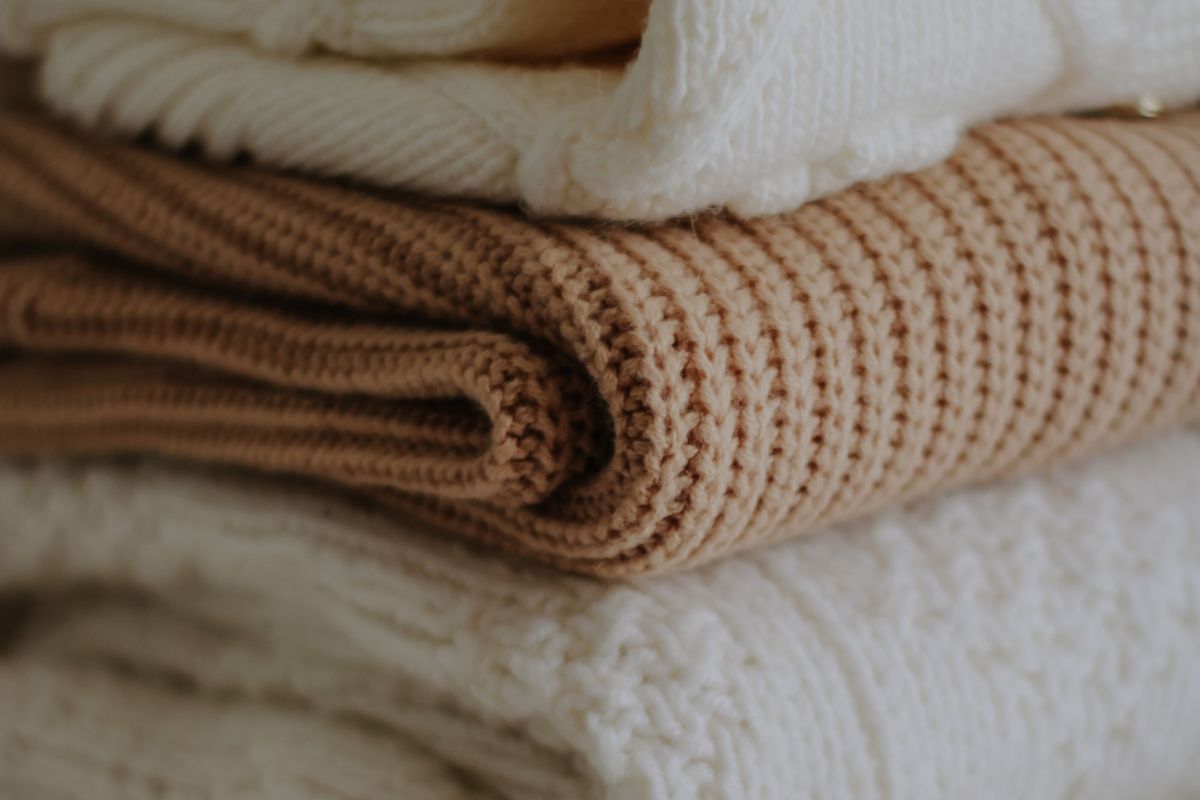 Ropa blanca y beige apilada.