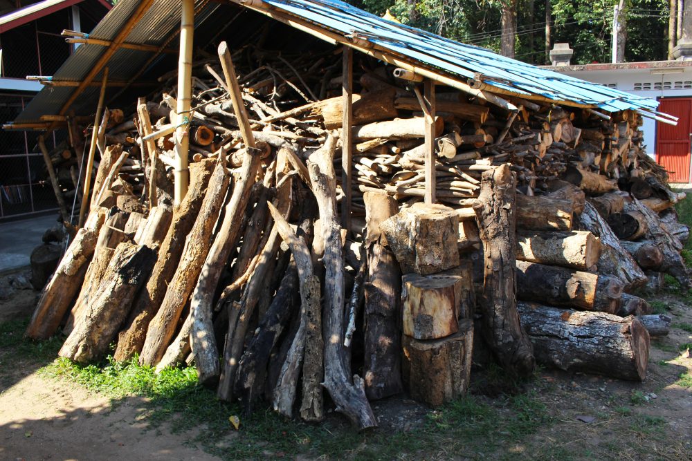 Montón de leña bajo un cobertizo de madera.