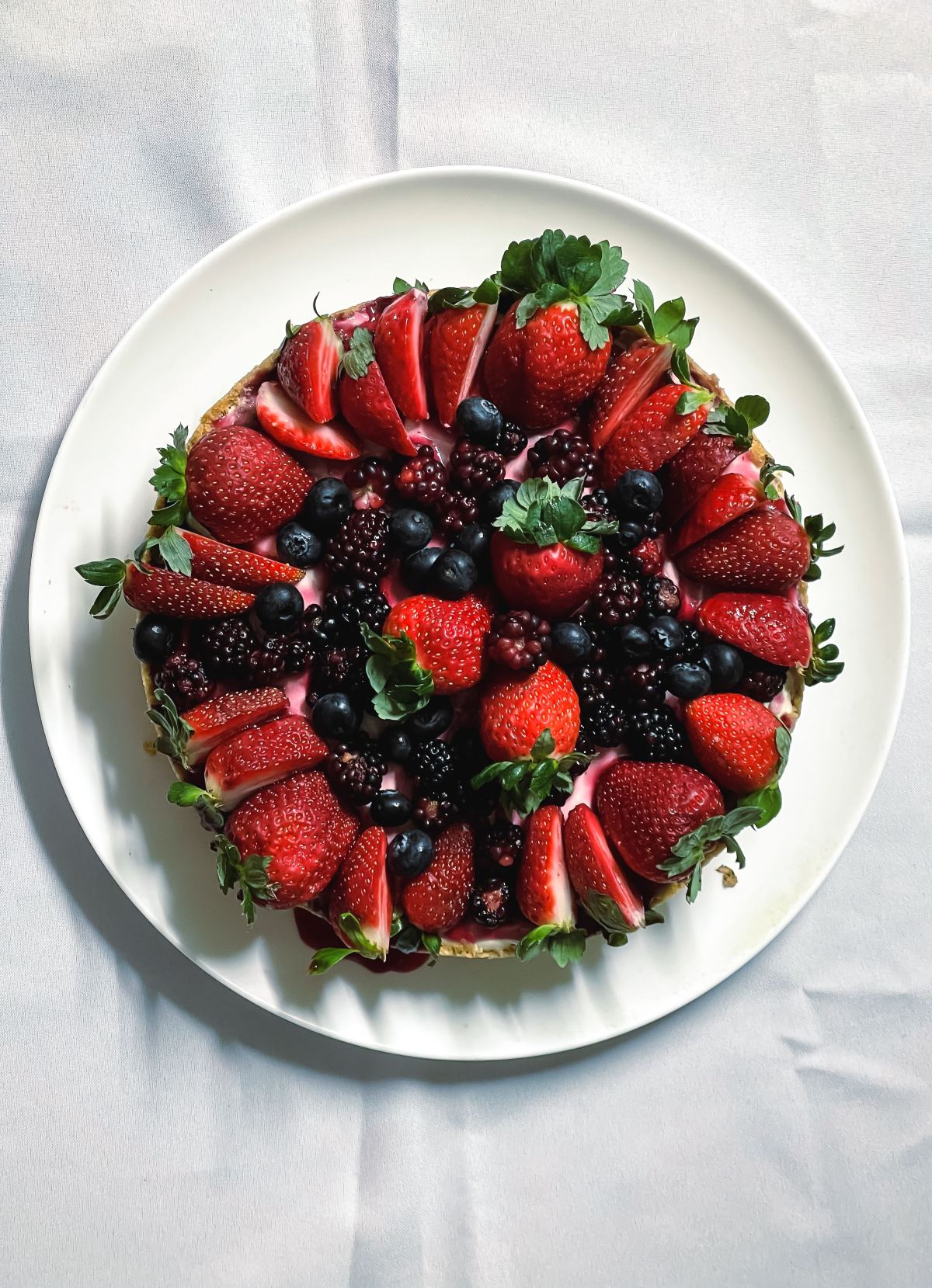 Tarta cubierta de frutillas, moras y arándanos, vista desde arriba