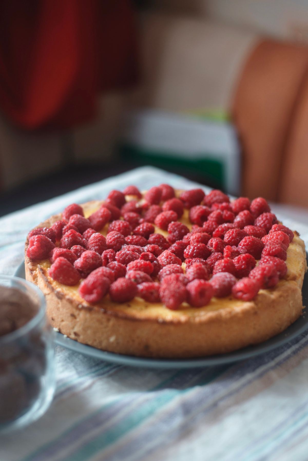 Tarta entera cubierta de frambuesas sobre la mesa