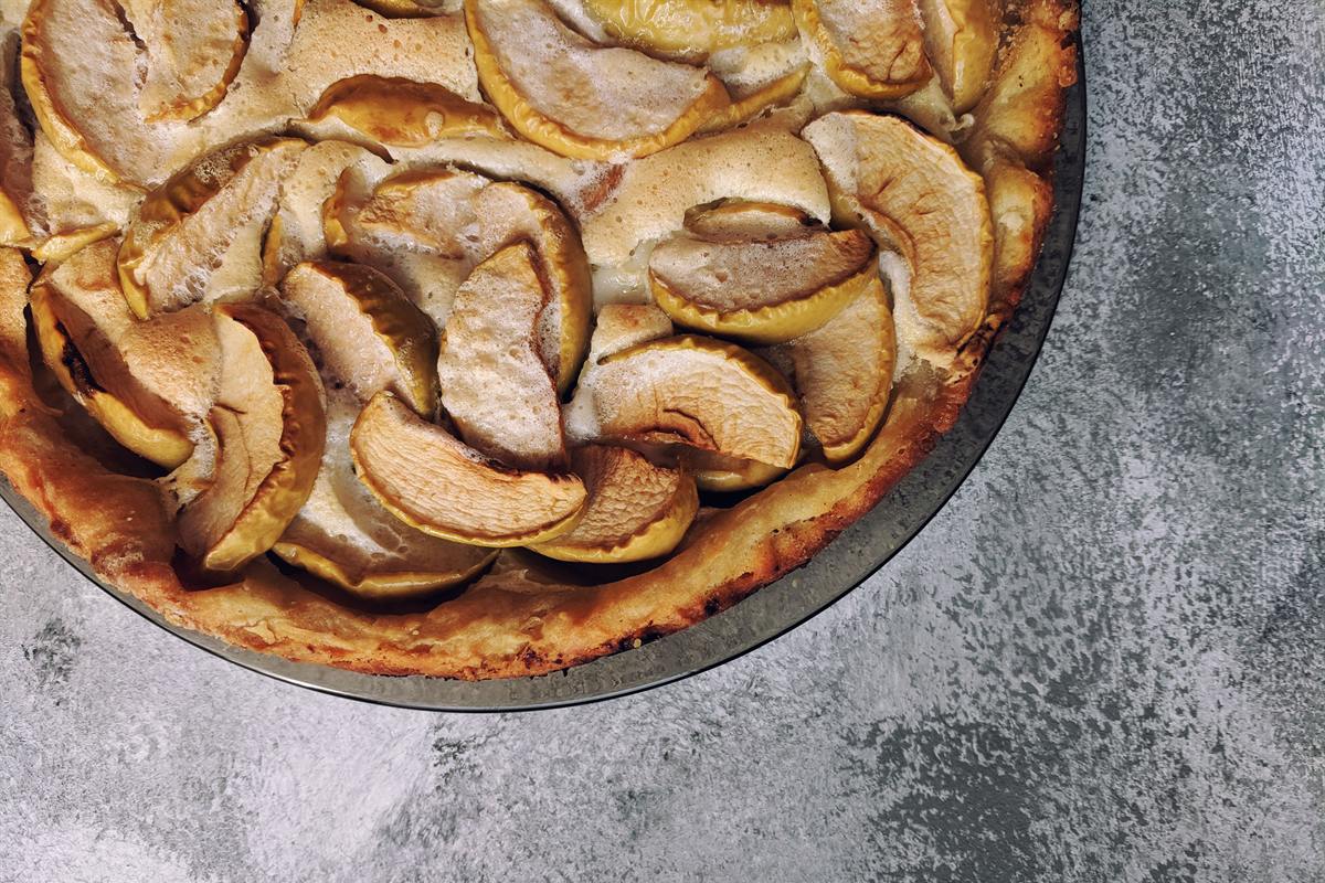 Kuchen de manzana entero, con los gajos ordenados sobre la masa, visto desde arriba