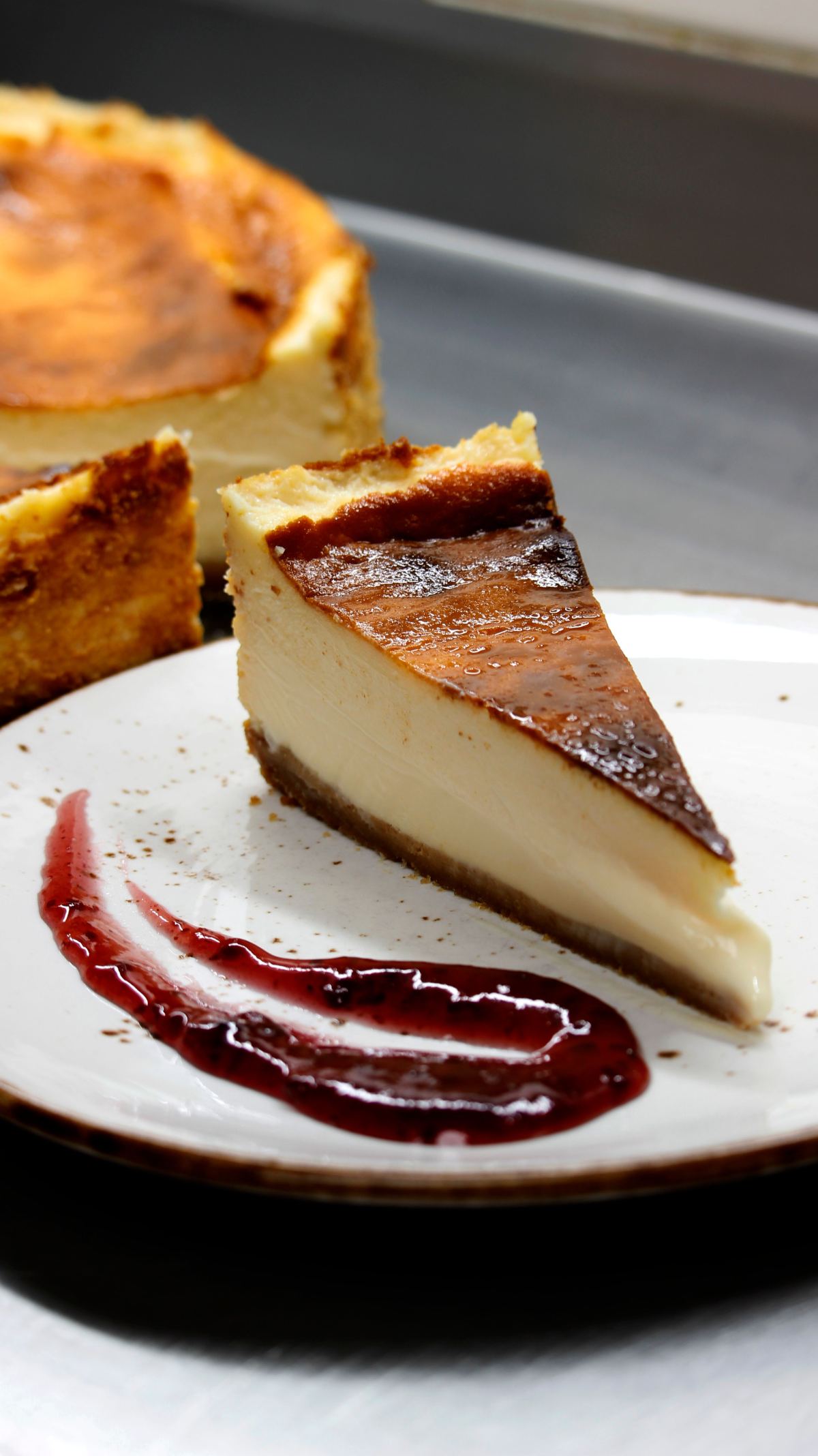 Trozo de tarta de queso con mermelada de frutos rojos en el plato