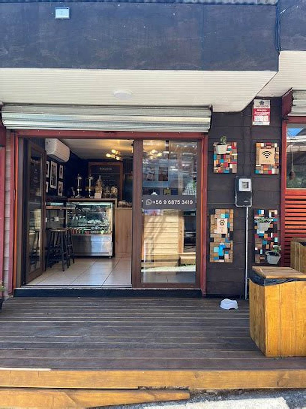 La puerta abierta del local, con el interior iluminado al fondo.