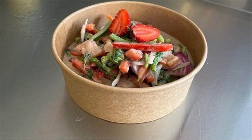 Una ensalada servida en bowl, con frutillas y hojas verdes.