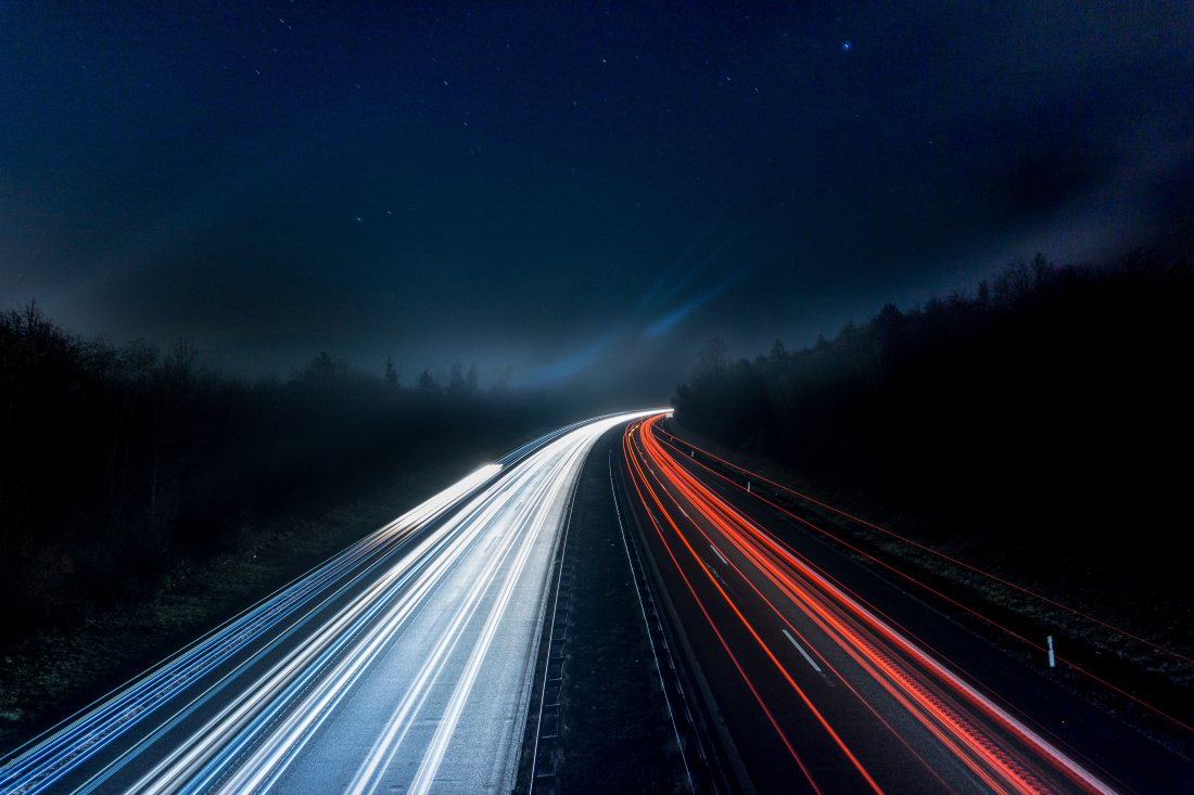 Estelas de luz en una carretera de noche.