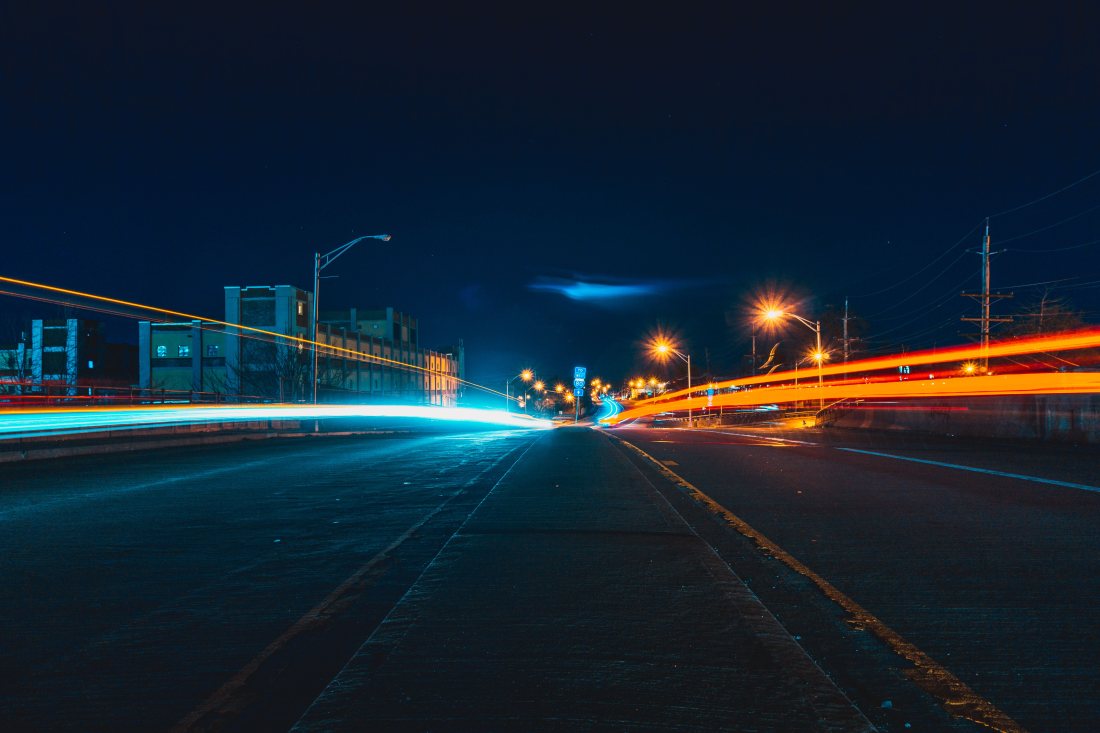 Calle nocturna con luces de la ciudad.