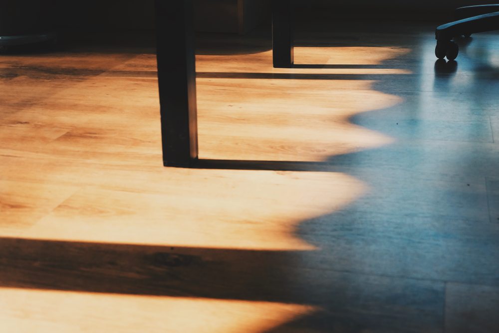 El piso de madera de una habitación con la luz de la ventana.
